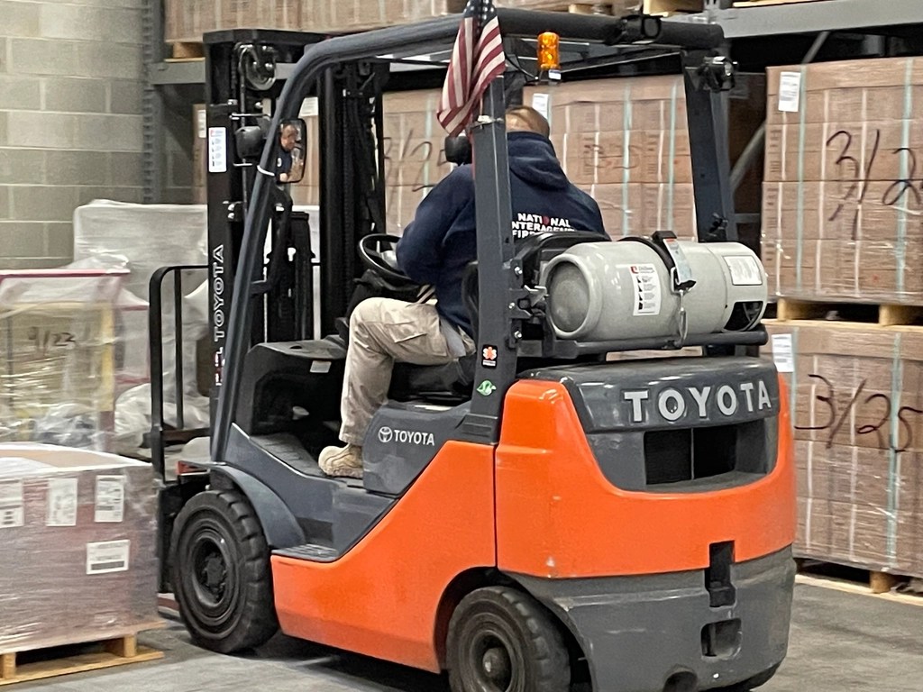 A forklift moving boxes in a returns warehouse